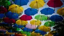 Payung warna-warni bagian dari instalasi seni Umbrella Sky menggantung di atas Coral Gables, Florida, 16 Juli 2018. Selain menciptakan pemandangan indah, payung-payung tersebut dapat melindungi orang-orang dari sengatan sinar matahari. (AP/Brynn Anderson)