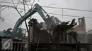 Ekskavator meratakan Sanggar Saung Merdeka Ciliwung Bukit Duri, Jakarta, Rabu (28/9). Penghuni sanggar dan sejumlah warga mulai memainkan angklung, memukul kaleng dan panci sambil menatap sanggar tersebut runtuh. (Liputan6.com/Yoppy Renato)