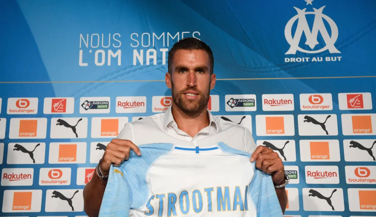 Gelandang baru Marseille, Kevin Strootman berpose dengan jersey klub barunya selama presentasi dirinya di Marseille, Prancis, (28/8). Pemain asal Belanda ini di beli Marseille dari AS Roma sebesar 25 juta euro. (AFP Photo/Christophe Simon)