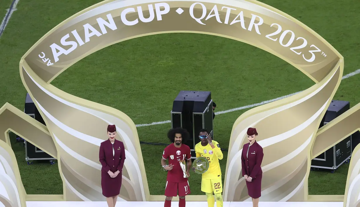 Meshaal Barsham (kanan) dan Akram Afif berfoto bersama saat mendapatkan pengharagaan kiper terbaik dan pemain terbaik Piala Asia 2023 di Lusail Stadium, Doha, Qatar, Sabtu (10/02/2024). (AP Photo/Hussein Sayed)