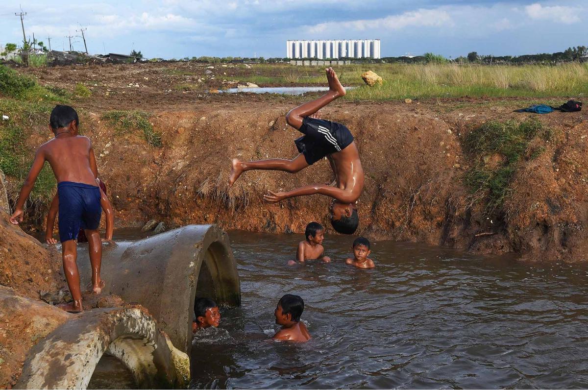 FOTO: Keceriaan Anak-Anak Bermain Pada Saluran Air di Tanjung Pasir