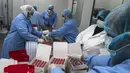 Sejumlah pekerja laboratorium saat mengisi kotak dengan botol vaksin Sinovac di laboratorium Vacsera, Kairo, Mesir, Rabu (1/9/2021). Mesir berencana memproduksi satu miliar dosis Sinovac setiap tahun dan menjadikan produsen vaksin terbesar di Timur Tengah dan Afrika. (AFP/Khaled Desouki)
