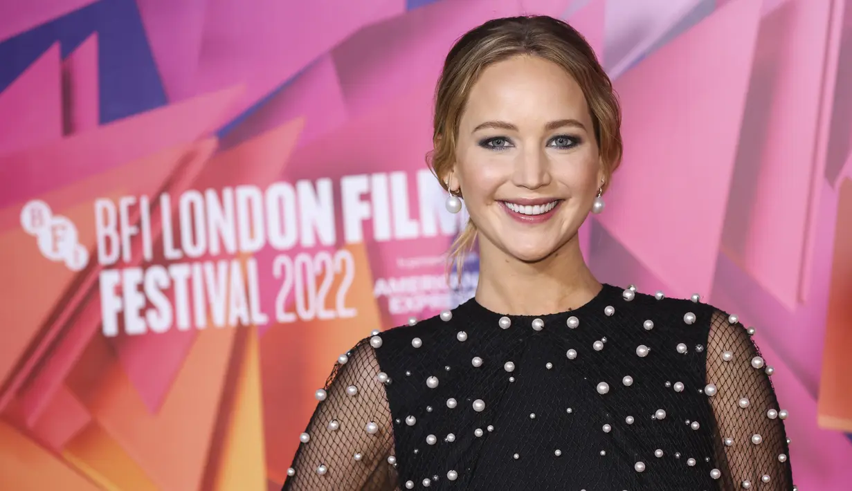 Jennifer Lawrence berpose sambil tersenyum saat menghadiri pemutaran perdana film ' Causeway' selama Festival Film London 2022 di London, Sabtu, 8 Oktober 2022. Desain cantik menyapu sosoknya dengan indah dan menampilkan lengan mengembang yang dramatis untuk memberikan sentuhan gaya pada penampilannya. (Photo by Vianney Le Caer/Invision/AP)