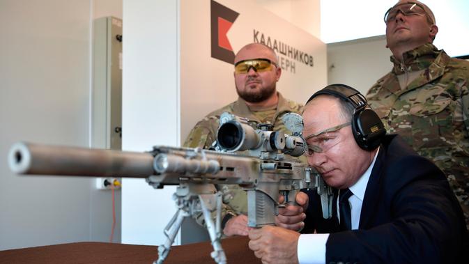 Presiden Rusia, Vladimir Putin menguji coba senapan sniper saat mengunjungi pameran Kalashnikov Concern di Patriot Park, luar Moskow, Rabu (19/9). Putin juga memeriksa perangkat keras militer yang dipamerkan (Alexei Nikolsky, Sputnik, Kremlin Pool via AP)
