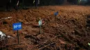 Personel kepolisian berjalan melewati makam korban banjir tak dikenal yang diberi tanda nomor di lokasi pemakaman massal di Devghat, Distrik Chitwan, Nepal, Minggu, 30 Agustus 2026. (AFP/ Prakash Mathema)