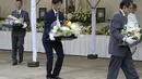 Bunga yang dipersembahkan oleh para pelayat dipindahkan dari altar saat semakin banyak orang datang dan berdoa untuk mantan Perdana Menteri Jepang Shinzo Abe di kuil Zojoji, Tokyo, Sabtu (8/7/2023). (AP Photo/Shuji Kajiyama)