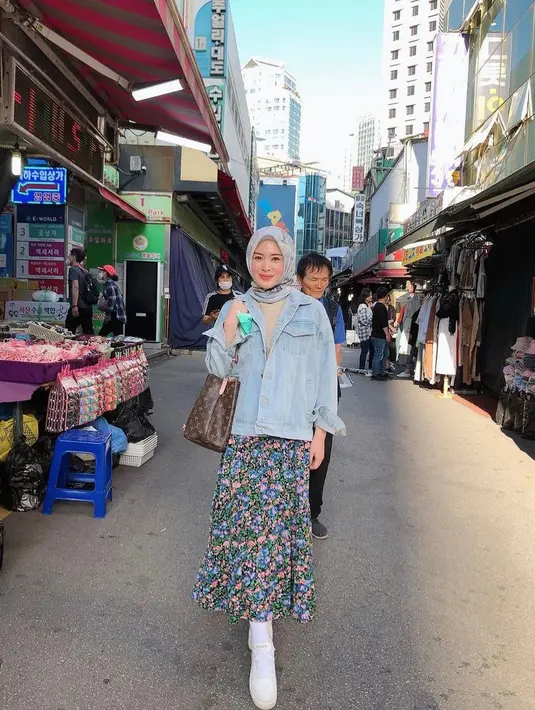 Selebgram Ayana Moon tampil manis dalam balutan jaket jeans dan rok floral. Untuk hijab, Ayana memilih hijab bermotif warna biru yang senada dengan jaketnya. (Instagram/xolovelyayana).