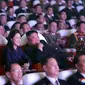 Gambar yang dirilis pada 17 Februari 2021 menunjukkan Pemimpin Korea Utara Kim Jong-un (tengah) dan istrinya Ri Sol Ju menonton pertunjukan di Pyongyang. Ri biasanya sering menemani Kim Jong-un ke acara-acara publik besar, namun dia tidak terlihat sejak Januari 2020. (STR/AFP/KCNA VIA KNS)