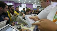 Salah satu kasir memindai iPhone 6 di sebuah toko ponsel di Moskow, Jumat, (26/9/2014). (REUTERS/Maxim Shemetov)