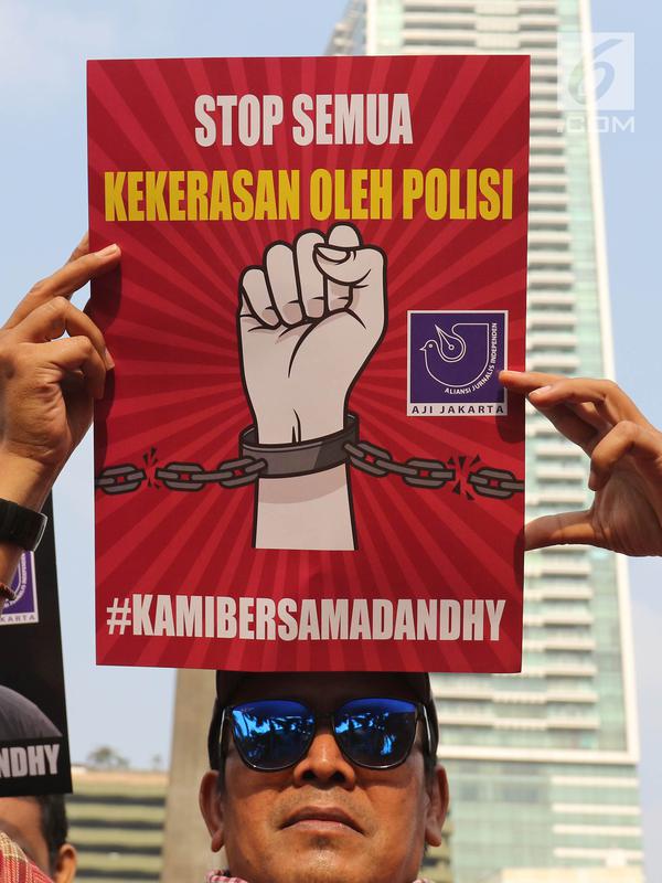Jurnalis yang tergabung dalam Aliansi Jurnalis Independen (AJI) menunjukkan poster saat menggelar aksi pada Car Free Day di Bundaran HI, Jakarta, Minggu (29/9/2019). Dandhy Laksono ditangkap atas dugaan ujaran kebencian berdasarkan SARA karena cuitannya di Twitter. (Liputan6.com/Herman Zakharia)