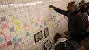 Sejumlah warga menempelkan post-it sebagai bagian 'subway therapy' di dinding stasiun Union Square, New York, Kamis (10/11). Subway therapy digunakan kaum komuter yang kesal dan kecewa dengan terpilihnya Donald Trump sebagai Presiden AS (DREW ANGERER/AFP)