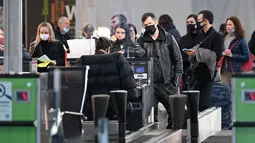 Pelancong menunggu di konter check-in sebelum penerbangan mereka di bandara Boryspil, luar Kiev, 13 Februari 2022. Ukraina berjanji menjaga wilayah udaranya terbuka untuk perjalanan internasional setelah negara Barat memperingatkan pasukan Rusia dapat menyerang kapan saja. (Sergei Supinsky/AFP)