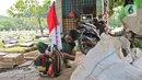 Petugas Pertamanan dan Kehutanan Kota Jakarta Pusat menyiapkan mesin potong rumput di TPU Karet Bivak, Jakarta, Minggu (16/8/2020). Dalam rangka menyambut HUT ke-75 RI, para petugas bekerja dengan mengenakan atribut kemerdekaan. (Liputan6.com/Herman Zakharia)