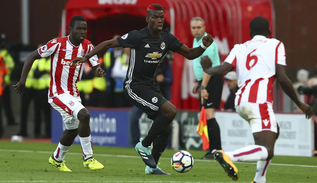 Gelandang Manchester United, Paul Pogba, berusaha melewati pemain Stoke City pada laga Premier League di Stadion bet365, Sabtu (9/9/2017). Manchester United bermain imbang 2-2 dengan Stoke City.(AFP/Geoff Caddick)