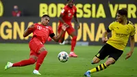 Gelandang Bayern Munchen, Serge Gnabry, berebut bola dengan bek Borussia Dortmund, Achraf Hakimi, pada laga pekan ke-28 Bundesliga di Stadion Signal Iduna Park, Selasa (26/5/2020) waktu setempat. Bayern Munchen menang 1-0 atas Borussia Dortmund. (AFP/Federico Gambarini/Pool)