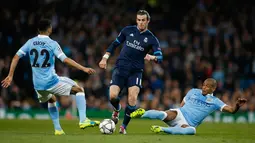 Gelandang Real Madrid, Gareth Bale (tengah) berusaha melewati dua pemain Manchester City pada leg pertama Semifinal Liga Champions di stadion Etihad, Inggris, (27/4). Real Madrid menahan imbang tuan rumah City dengan skor 0-0. (Reuters/Phil Noble)
