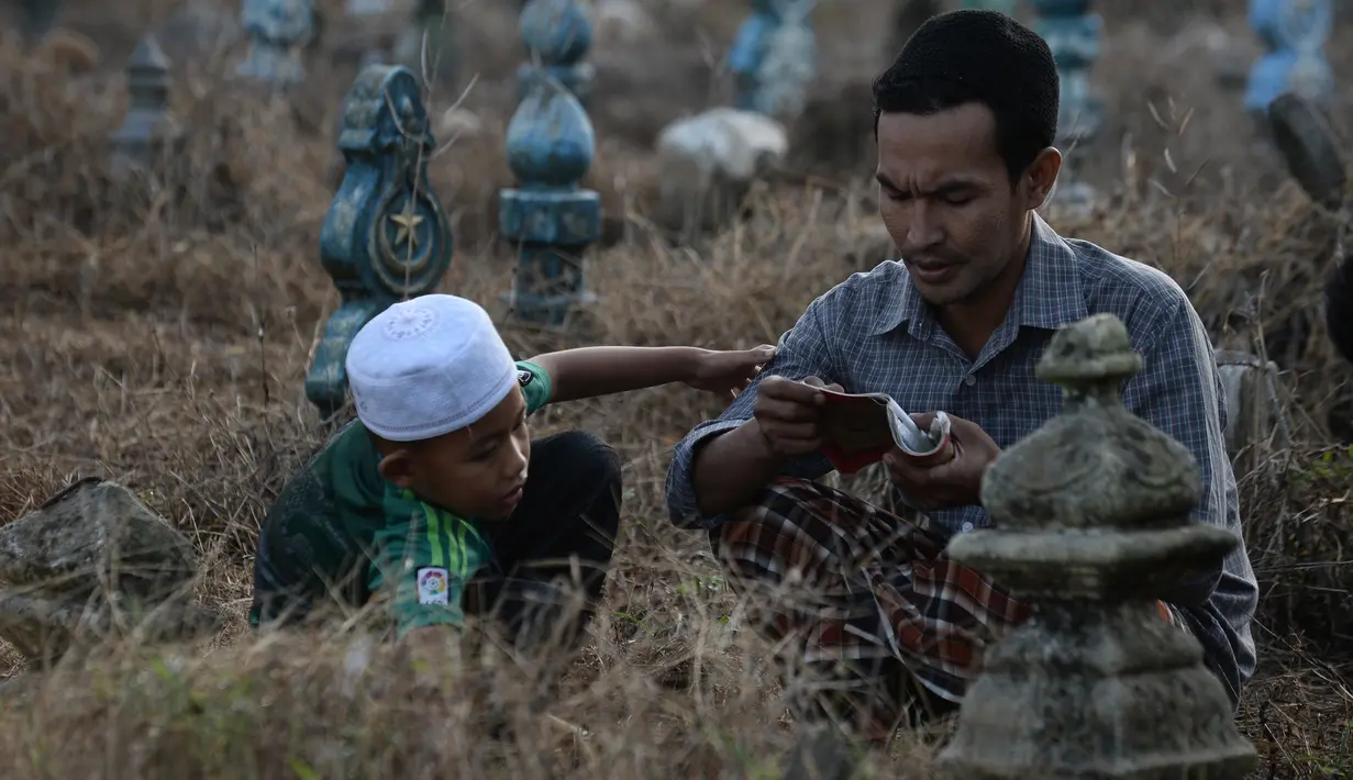 Muslim Thailand berdoa saat menziarahi kuburan kerabat mereka pada perayaan Idul Adha di provinsi Narathiwat, Minggu (11/8/2019). Pada setiap Idul Adha atau menyambut hari besar Islam sebagian warga banyak mendatangi kuburan untuk mendoakan keluarganya. (Madaree TOHLALA/AFP)