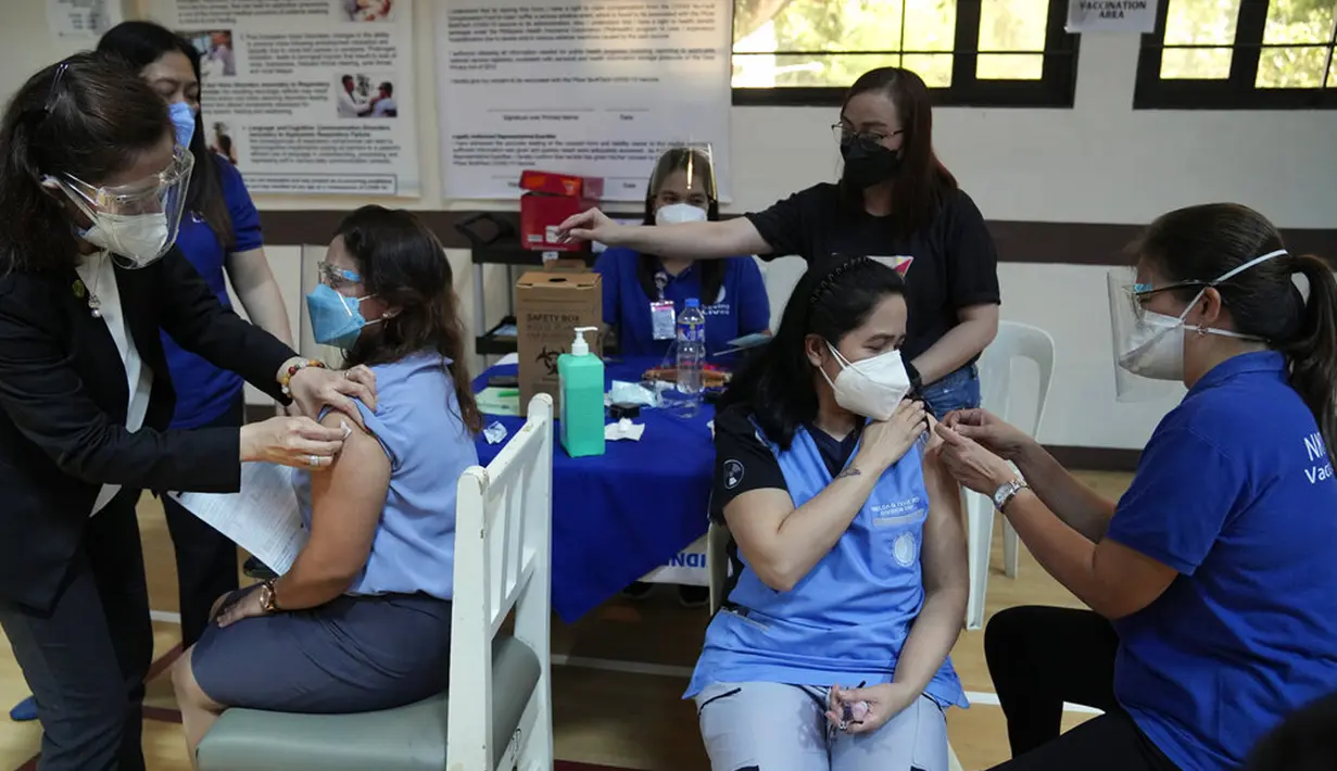 Petugas kesehatan bersiap untuk disuntik dengan vaksin COVID-19 Pfizer di National Kidney and Transplant Institute, Quezon City, Filipina, 17 November 2021. Pemerintah Filipina mulai menyuntikkan booster vaksin COVID-19 kepada pekerja garis depan. (AP Photo/Aaron Favila)