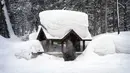 Seseorang duduk di halte bus yang tertutup salju di Olympic Valley, California, Amerika Serikat, 24 Februari 2023. California dan bagian lain di Barat menghadapi salju lebat dan hujan dari badai musim dingin terbaru yang melanda Amerika Serikat. (AP Photo/John Locher)
