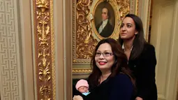 Senator Illinois, Tammy Duckworth membawa bayinya meninggalkan ruang kongres Gedung Capitol Hill, Washington DC, Kamis (19/4). Pekan lalu, Duckworth menjadi senator AS pertama yang melahirkan, saat masih aktif bekerja di Kongres. (AP/Manuel Balce Ceneta)