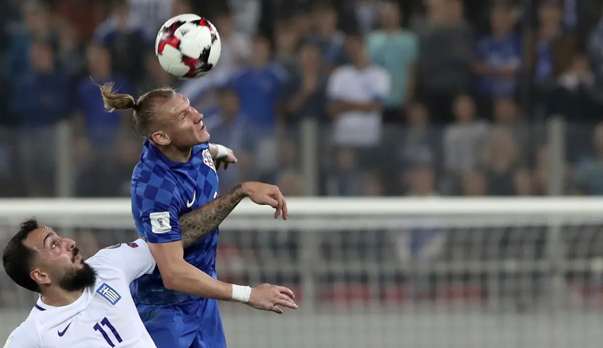 Pemain Yunani, Kostas Mitroglou berebut bola dengan pemain Kroasia, Domagoj Vida pada laga leg kedua play-off Piala Dunia 2018 di Stadion Karaiskakis, Senin (13/11). Timnas Kroasia berhasil memastikan langkah ke Piala Dunia 2018. (AP/Yorgos Karahalis)