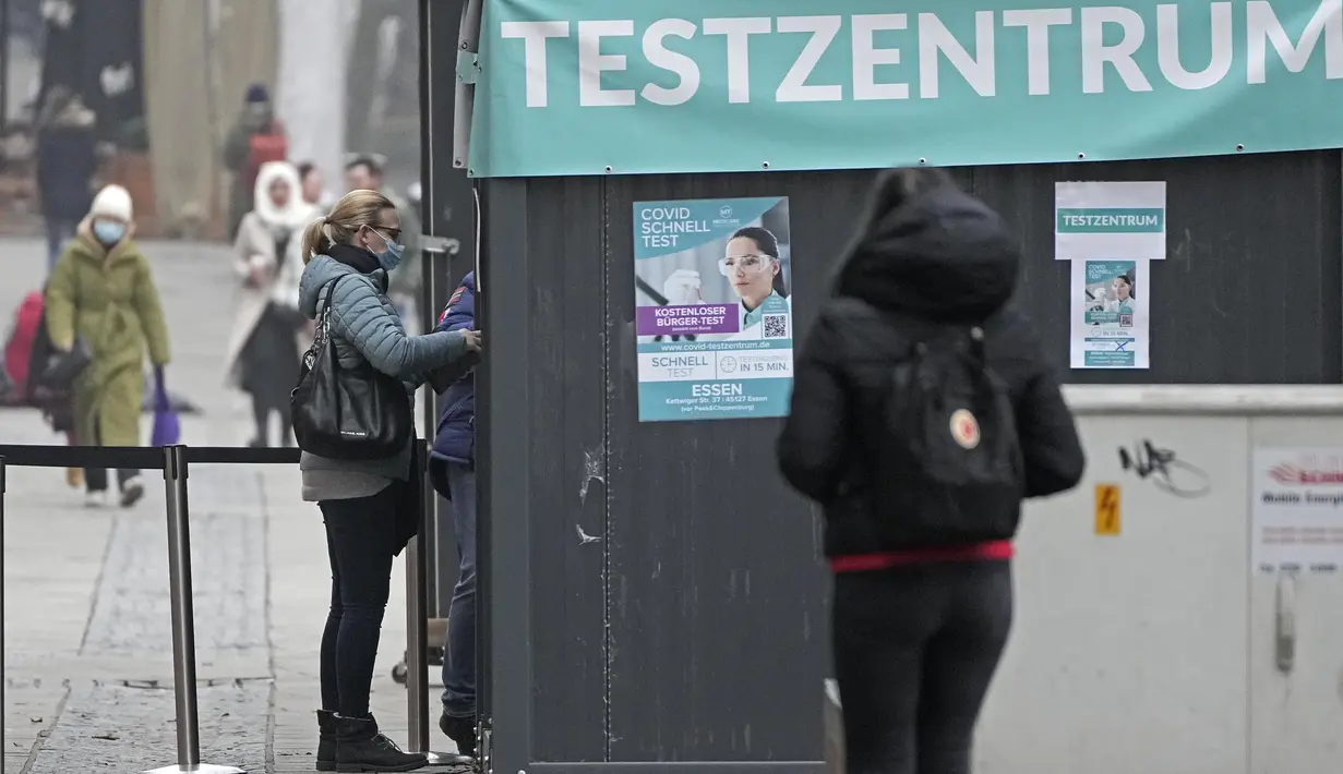 Orang-orang melakukan tes covid-19 di pusat kota Essen, Jerman, Rabu (12/1/2022). Jerman melaporkan lebih dari 80.000 kasus virus corona dalam sehari yang merupakan tertinggi sejak pandemi pada Rabu. (AP Photo/Martin Meissner)