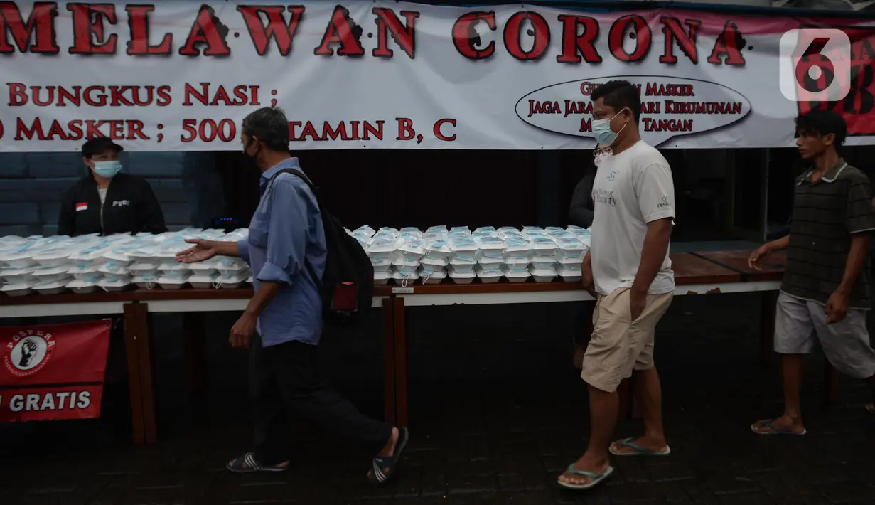 Warga menerima pembagian nasi bungkus gratis di Posko Perjuangan Rakyat (POSPERA), Jakarta, Rabu (10/3/2021). Pembagian 500 nasi bungkus beserta masker dan vitamin secara gratis setiap harinya dalam bentuk meringankan beban warga di tengah pandemi Covid-19. (merdeka.com/Imam Buhori)