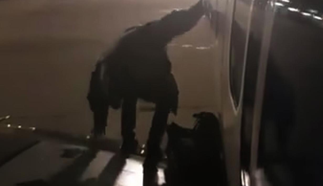 Seorang penumpang maskapai Ryanair keluar lewat pintu darurat di sayap pesawat di Bandara Malaga, Spanyol, Rabu (3/1). Tindakan pria ini menjadi viral ketika penumpang lain, Fernando del Vall, merekamnya dan viral di Facebook. (Fernando del Valle via AP)