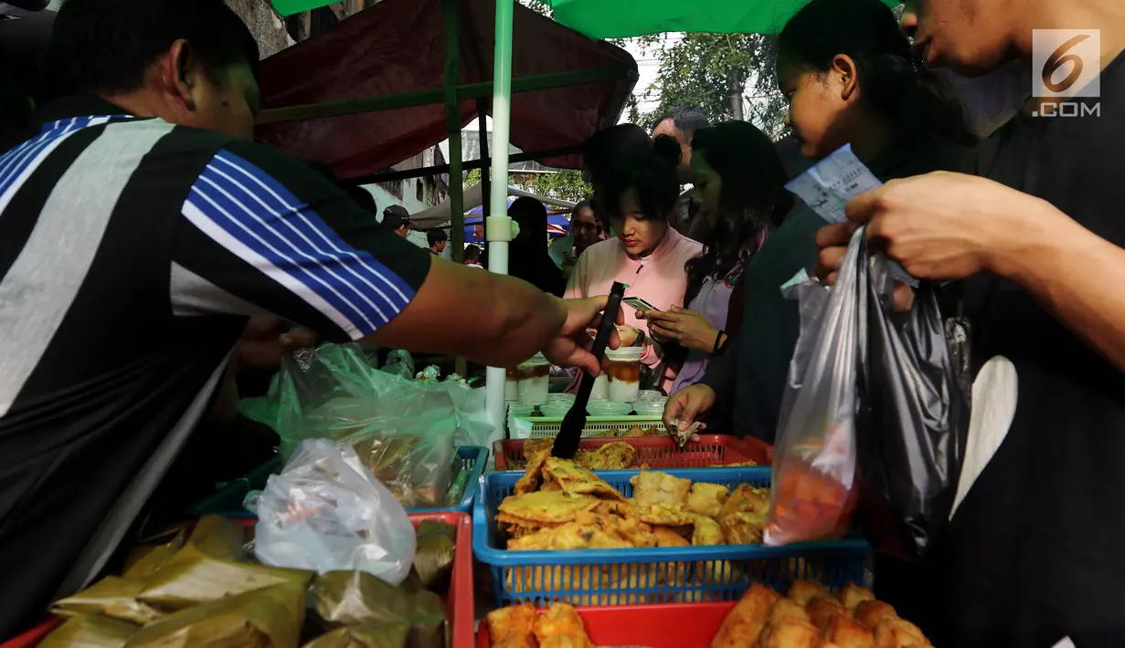 Warga membeli makanan untuk berbuka puasa di Pasar Takjil Kebon Kacang, Jakarta, Senin (29/5). Meski berada di gang sempit di antara gedung-gedung Pasar tersebut menjadi lokasi favorit warga yang bekerja di perkantoran sekitar. (Liputan6.com/Johan Tallo)