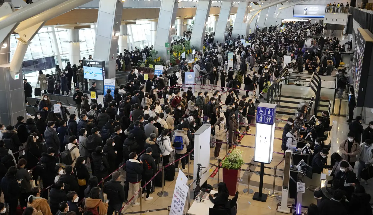 Penumpang yang mengenakan masker antre untuk naik pesawat menjelang liburan Tahun Baru Imlek, di terminal penerbangan domestik bandara Gimpo di Seoul, Korea Selatan, Sabtu (29/1/2022). Libur Imlek di Korsel dimulai mulai 30 Januari hingga 2 Februari mendatang. (AP Photo/Ahn Young-joon)