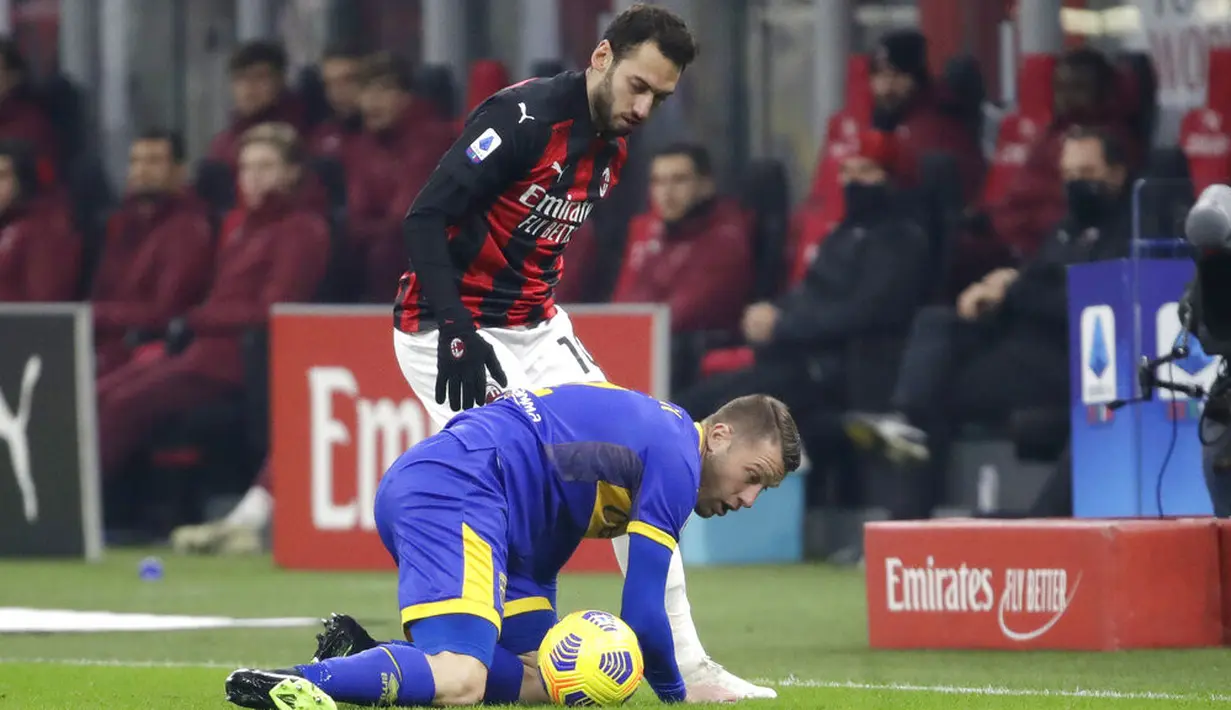 Pemain AC Milan Hakan Calhanoglu (kiri) berebut bola dengan pemain Parma Simone Iacoponi pada pertandingan Serie A di Stadion San Siro, Milan, Italia, Minggu (13/12/2020). AC Milan masih puncaki klasemen usai bermain imbang 2-2 lawan Parma. (AP Photo/Luca Bruno)