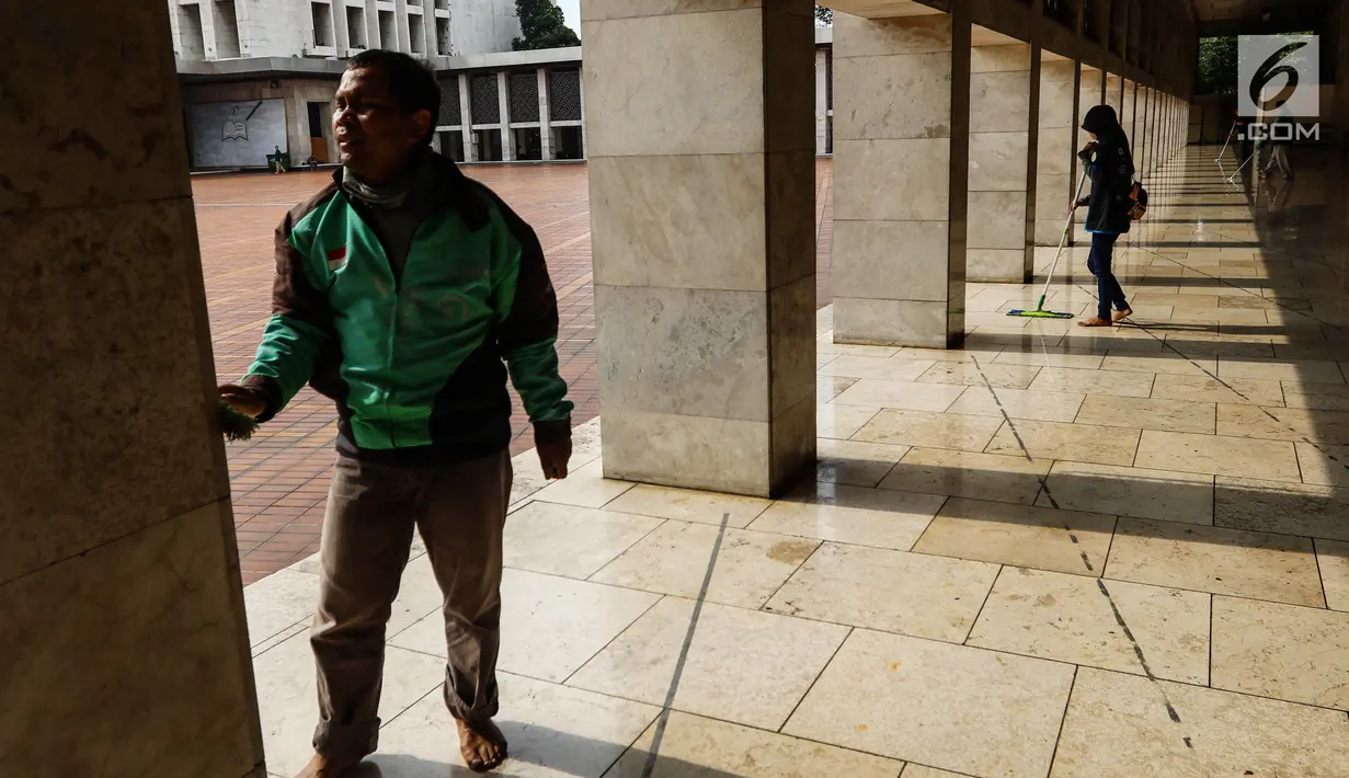 Driver Go-Jek sedang membersihkan lantai dalam rangka program Ramadan Tanpa Batas di Masjid Istiqlal, Jakarta, Kamis (15/06). Sebanyak 100 masjid di 11 kota dibersihkan untuk meningkatkan kenyamanan beribadah. (Liputan6.com/Fery Pradolo)
