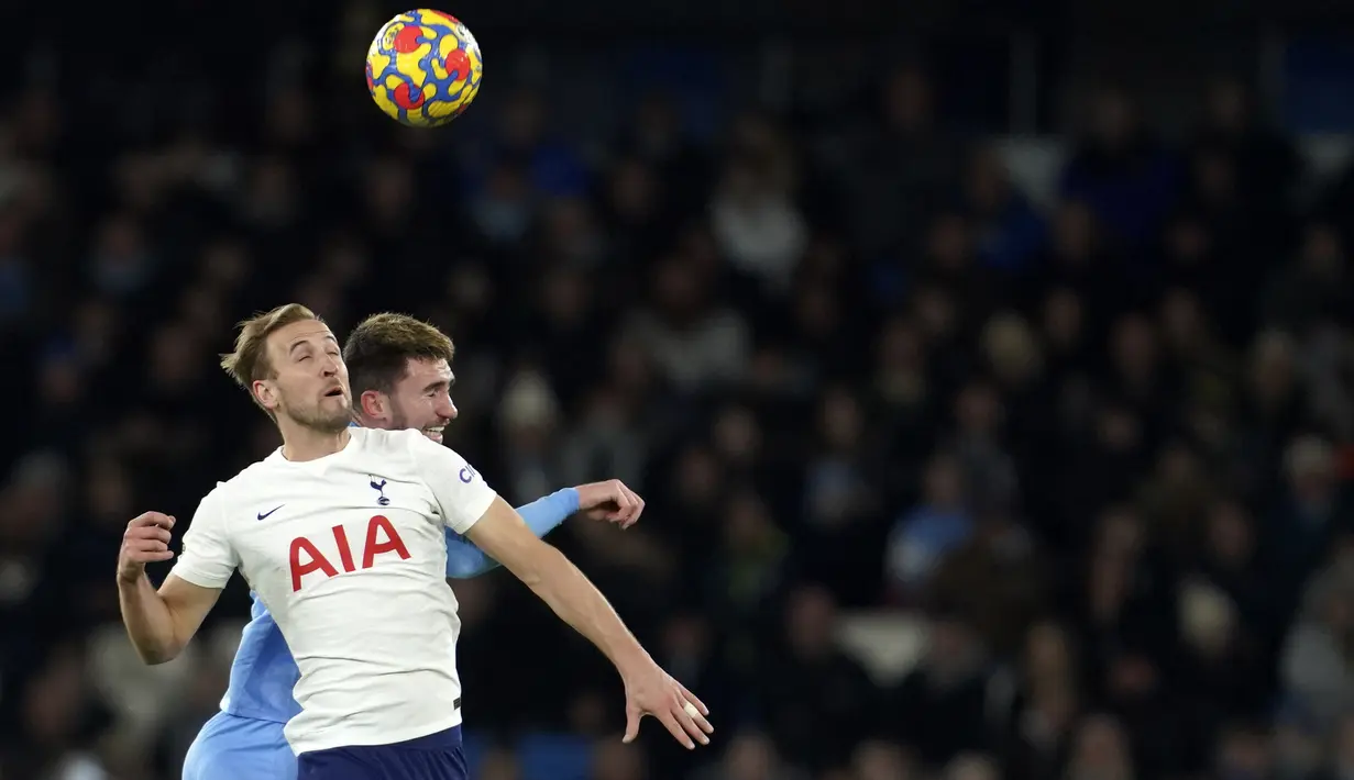 Penyerang Tottenham Hotspur Harry Kane melompat saat berebut bola dengan bek Manchester City Aymeric Laporte pada pekan ke-26 Liga Inggris di Etihad stadium, Minggu (20/2/2022) dinihari WIB. Manchester City takluk 2-3 dari tim tamu, Tottenham Hotspur.  (AP Photo/Jon Super)