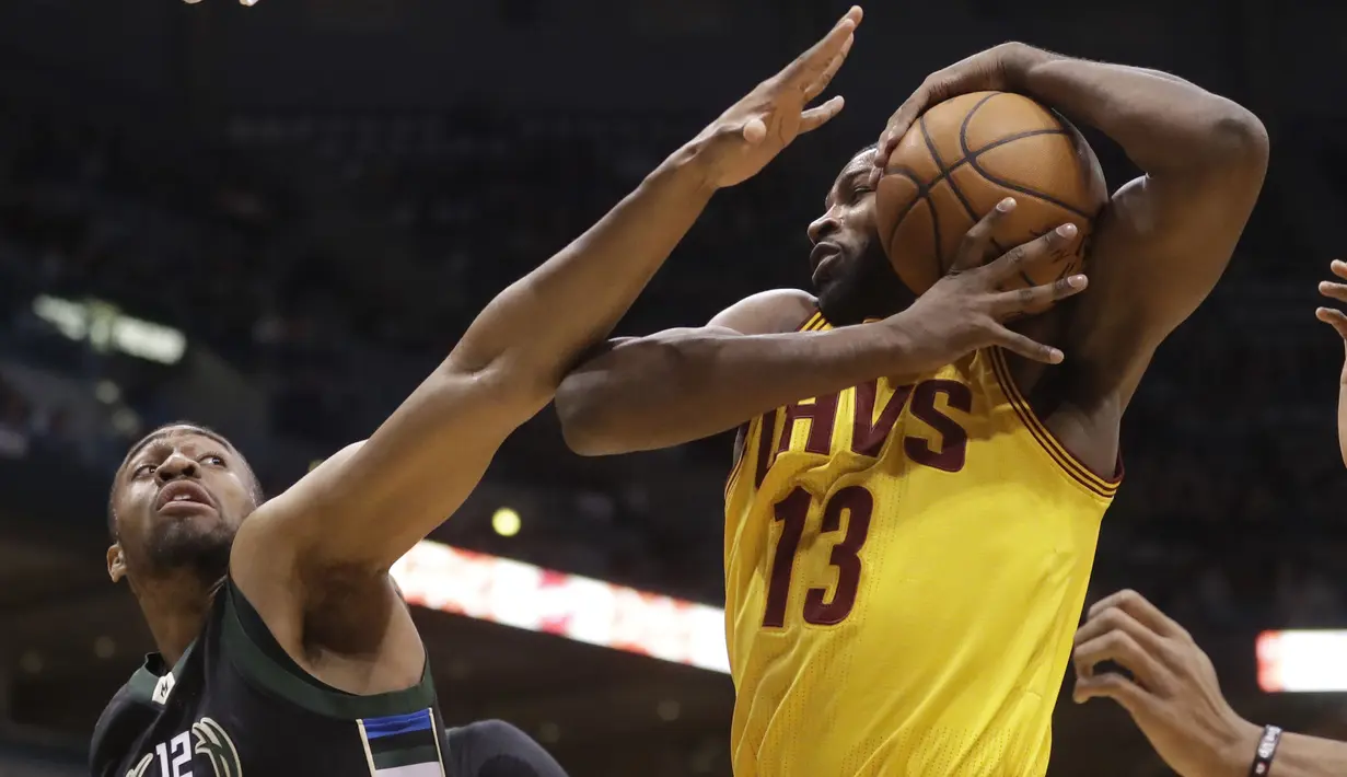 Pemain Cleveland Cavaliers, Tristan Thompson berusaha mengamankan bola dari kejaran pemain  Bucks, Jabari Parker (kiri) pada laga NBA di BMO Harris Bradley Center, (20/12/2016). Cavs menang 114-108.  (AP/Morry Gash)