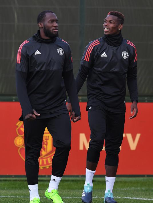 Pemain Manchester United, Romelu Lukaku (kiri) dan Paul Pogba memasuki lapangan tempat latihan di club training complex, Carrington, Manchester, (11/9/2017). MU akan melawan FC Basel di grup A Liga Champions. (AFP/Paul Ellis)