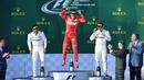 Pembalap Ferrari, Sebastian Vettel melompat merayakan kemenangannya di atas podium balapan GP Australia di Sirkuit Albert Park, Melbourne, Minggu (26/3). Ini merupakan kemenangan pertama Vettel bersama Ferrari sejak GP Singapura 2015. (WILLIAM WEST/AFP)