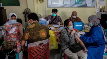 Warga menerima dosis vaksin booster COVID-19 Pfizer di Surabaya, Jawa Timur, Kamis (13/1/2022). (JUNI KRISWANTO/AFP)