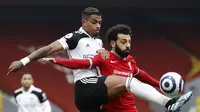 Pemain Fulham, Mario Lemina (kiri) mencuri bola dar penyerang Liverpool, Mohamed Salah, pada laga Liga Inggris di Stadion Anfield, Minggu (7/3/2021). (AFP/Phil Noble)
