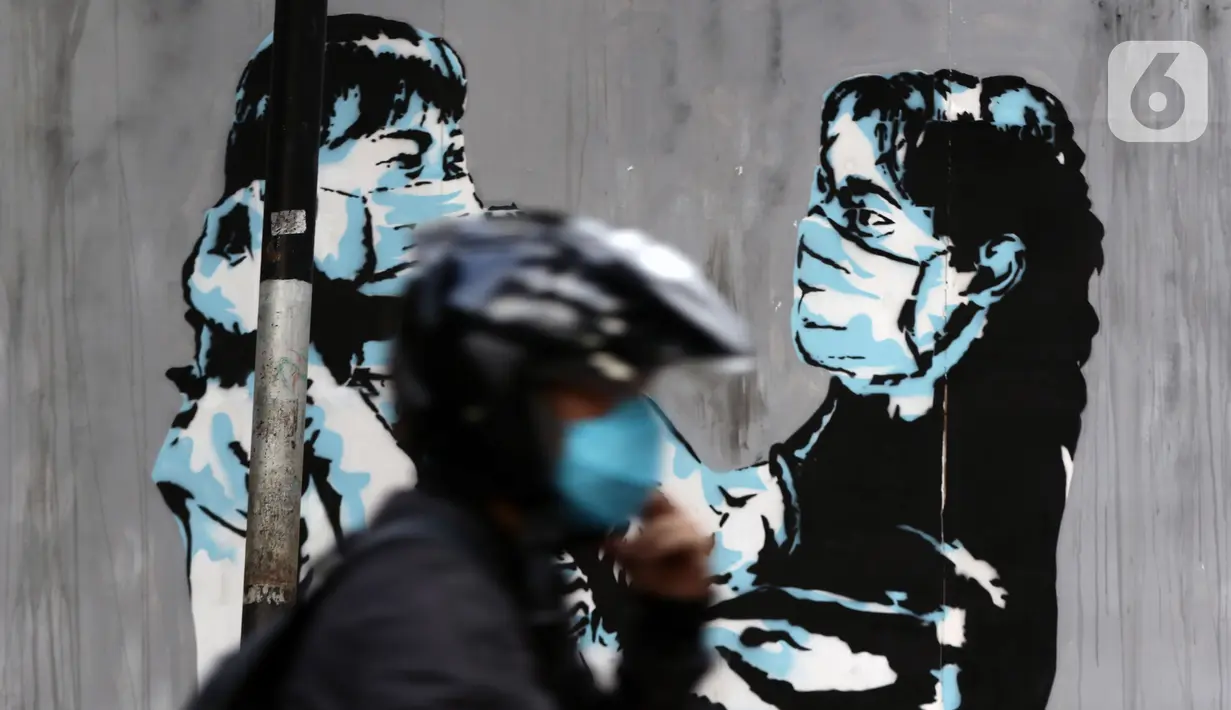 Pengendara melintas di depan mural protokol kesehatan COVID-19 di Jakarta, Minggu (21/11/2021). Untuk mencegah lonjakan kasus Covid-19, pemerintah akan menerapkan kebijakan PPKM Level 3 untuk seluruh wilayah Indonesia selama masa libur Natal 2021 dan Tahun Baru 2022.(Liputan6.com/Helmi Fithriansyah)