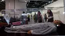 Pengunjung melihat replika Mao Zedong karya seniman Tiongkok yang bernama Shen Shaomin yang dipamerkan dalam Art Basel di Hong Kong (22/3). Karya replika sejumlah tokoh diktator ini banyak menyita perhatian pengunjung. (AFP/Anthony Wallace)