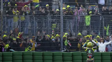 Pembalap Petronas Yamaha SRT, Valentino Rossi, melambaikan tangan kepada para penggemarnya di akhir balapan MotoGP Emilia Romagna di sirkuit Misano, Minggu (24/10/2021). MotoGP Emila Romagna menjadi balapan terakhir Rossi di tanah kelahirannya, Italia. (AP Photo/Antonio Calanni)