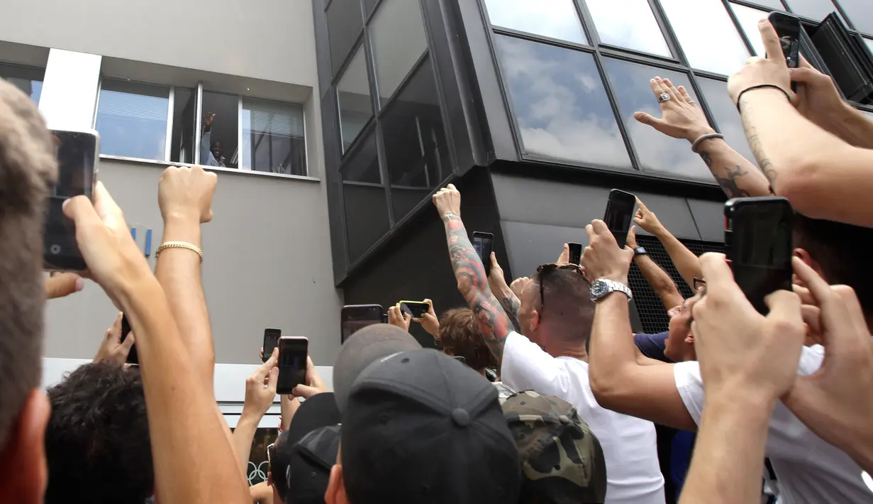 Fans Inter Milan mengangkat tangan saat pemain sepak bola Romelu Lukaku menyapa mereka dari jendela markas Komite Olimpiade Italia di Milan, Italia, Kamis (8/8/2019). Lukaku dikontrak lima tahun hingga Juli 2024 dan mendapat gaji sekitar 9 juta euro per musim plus bonus. (AP Photo/Luca Bruno)