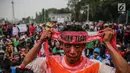 Seorang massa dari Aliansi Nelayan Indonesia memasang ikat kepala saat berunjuk rasa di depan Istana Merdeka, Jakarta, Selasa (11/7). Dalam aksi itu, mereka menyampaikan tuntutannya terkait kebijakan Menteri Susi Pudjiastuti. (Liputan6.com/Faizal Fanani)
