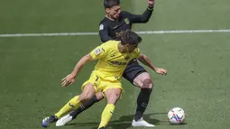 Pemain Villarreal, Gerard Moreno berebut bola dengan pemain Barcelona, Clement Lenglet pada pertandingan La Liga Spanyol di stadion Ceramica di Villarreal, Spanyol (25/4/2021). Baracelona menang tipis 2-1 atas Villarreal. (AP Photo/Alberto Saiz)