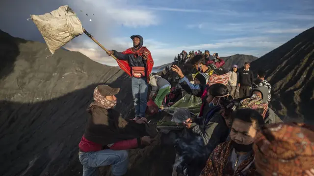 FOTO: Upacara Yadnya Kasada, Suku Tengger Larung Sesajen ke Kawah Gunung Bromo