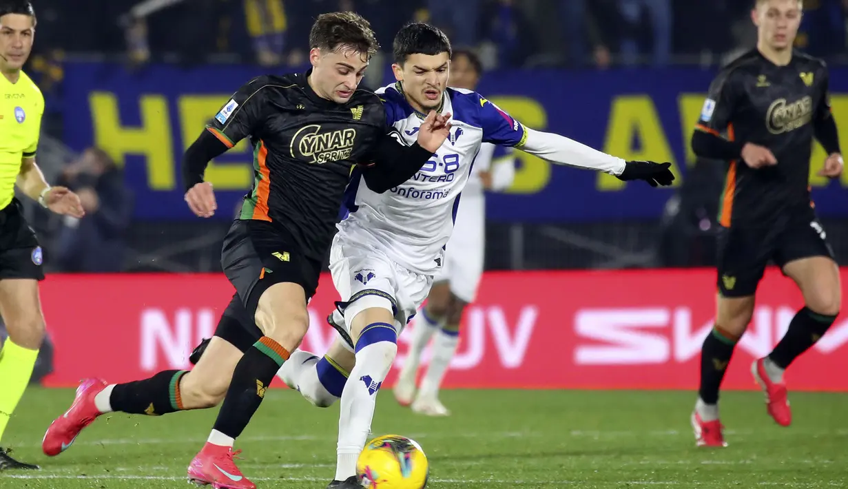 Pemain Venezia, Gaetano Oristanio berebut bola dengan pemain Hellas Verona, Reda Belahyane dalam laga lanjutan Liga Italia 2024/2025 di Venice, Italia, Selasa (28/01/2025) dini hari WIB. (AP Photo/LaPresse/Paola Garbuio)