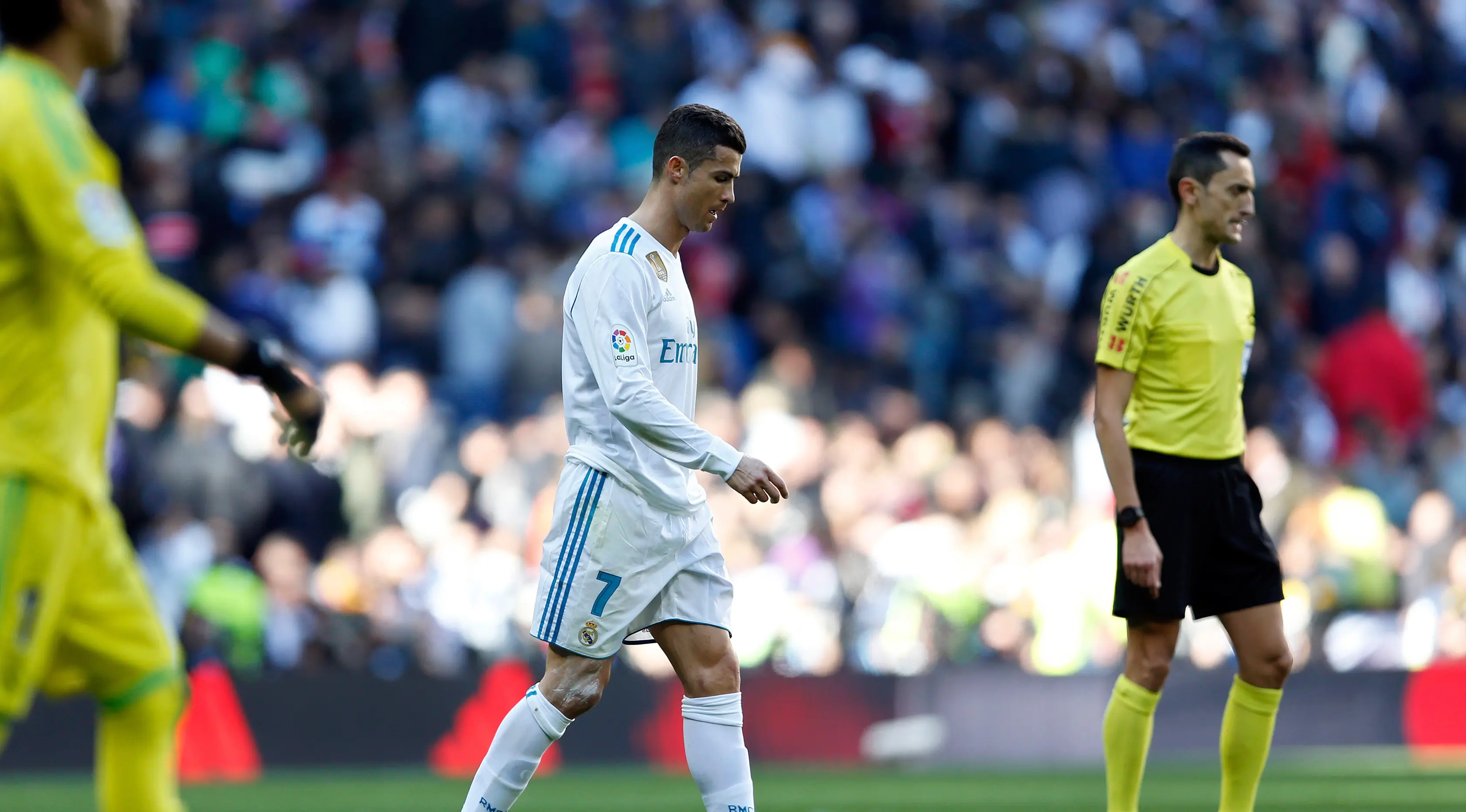 Penyerang Real Madrid Cristiano Ronaldo berjalan didekat wasit saat pertandingan melawan Barcelona dalam Liga Spanyol di stadion Santiago Bernabeu di Madrid, Spanyol (23/12). (AP Photo/Francisco Seco)