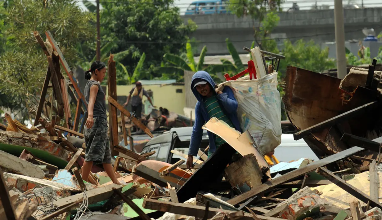 Pemulung mencari sisa barang diantara reruntuhan bangunan kios pedagang Terminal Depok, Jawa Barat yang dibongkar, (8/10/2014). (Liputan6.com/Helmi Fithriansyah)