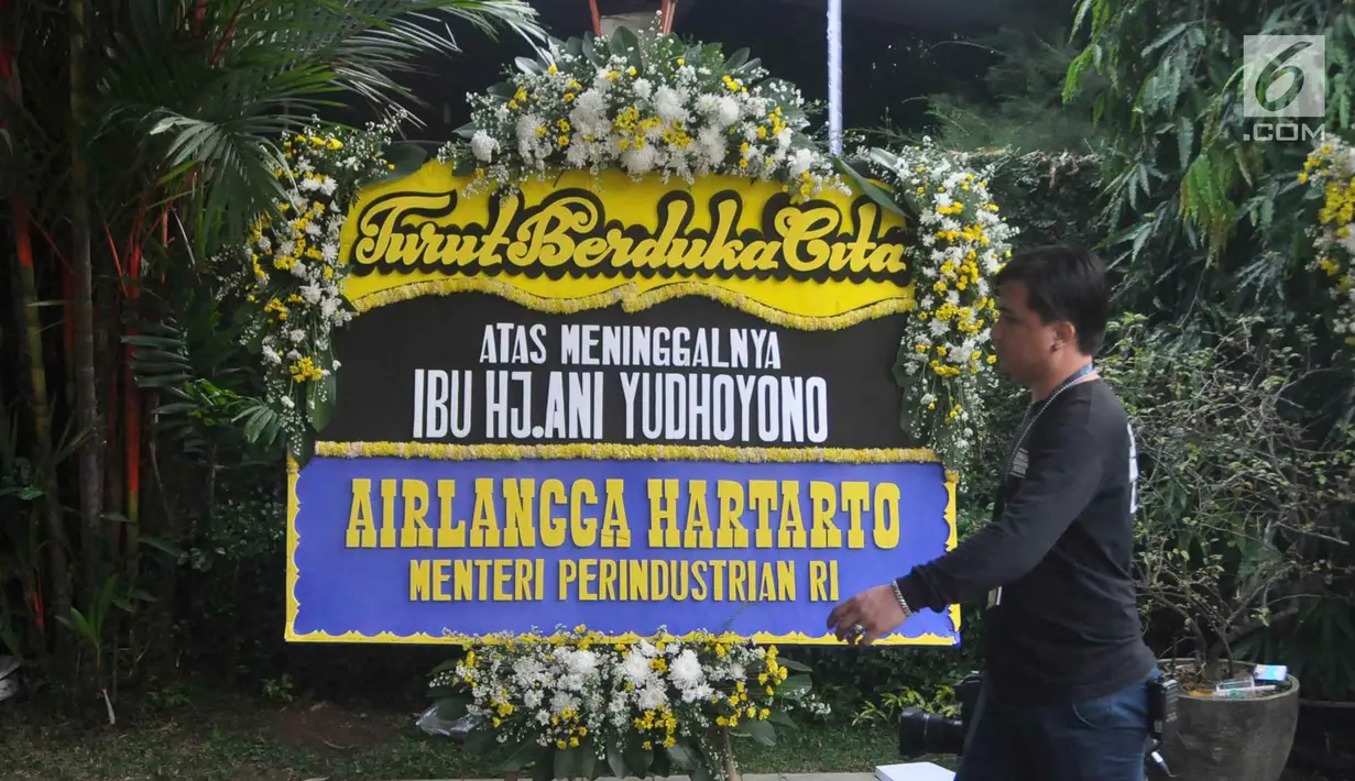 Seorang pria berjalan melewati karangan bunga ucapan bela sungkawa wafatnya Ani Yudhoyono menghiasi kawasan Puri Cikeas, Bogor, Jawa Barat, Minggu (2/6/2019). Ani Yudhoyono akan dimakamkan di samping pusara istri presiden ke-3 RI BJ Habibie, Ainun. (Liputan6.com/Immanuel Antonius)