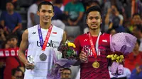 Tunggal putra Indonesia, Anthony Sinisuka Ginting dan Jonatan Christie saat penganugerahan medali seusai final Korea Terbuka 2017, Minggu (17/9). Anthony Ginting keluar sebagai juara Korea Terbuka 2017, 21-13, 19-21, 22-20. (JUNG Yeon-Je/AFP)